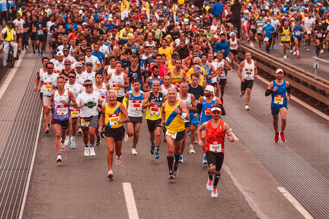 Large group of diverse athletes running a marathon outdoors during the day.