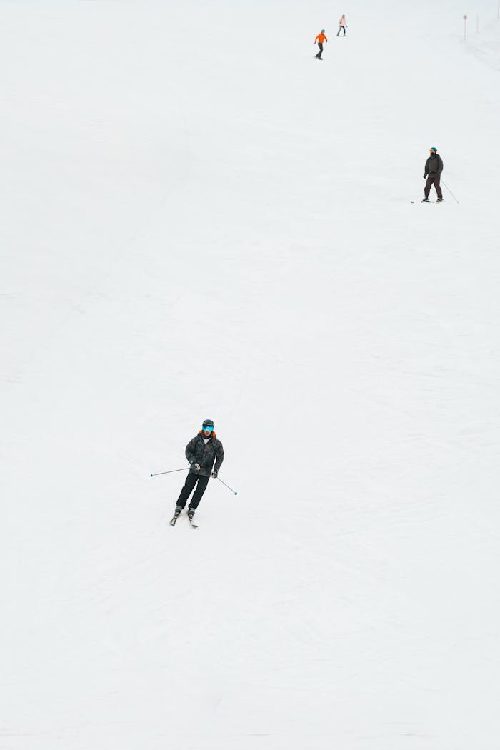 A group of skiers navigating down a snowy ski slope on a winter day, creating a serene scene.